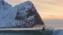 Seorang peselancar tengah beraksi di kawasan pantai  Flackstad, dekat Ramberg, kepulauan Lofoten, Arctic Circle, (9/3/2016). (AFP/Olivier Morin)