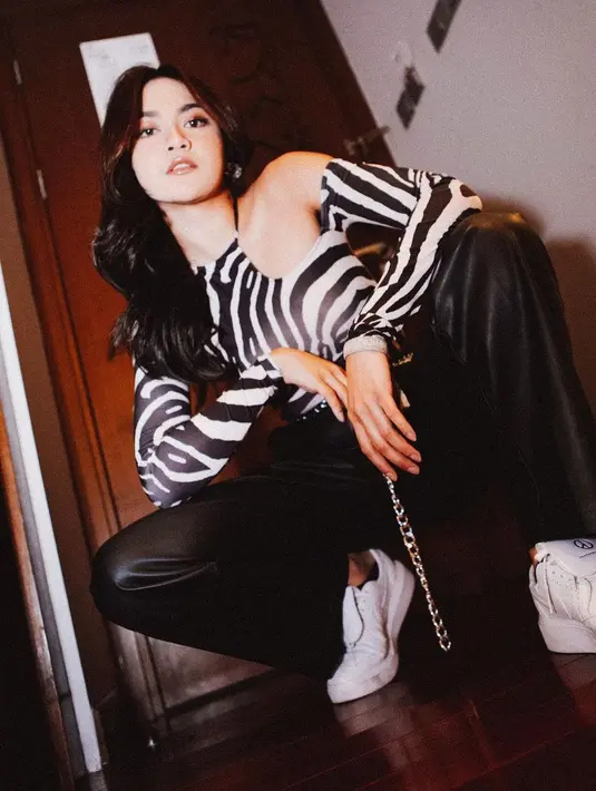<p>Tampilan manggung Mahalini yang ini juga tak kalah nyentrik. Dengan cut-out top lengan panjang bermotif zebra, Mahalini menonjolkan nuansa kasual dengan celana latex hitam dan sneakers putih yang seirama dengan keseluruhan tampilannya. Foto: Instagram.</p>