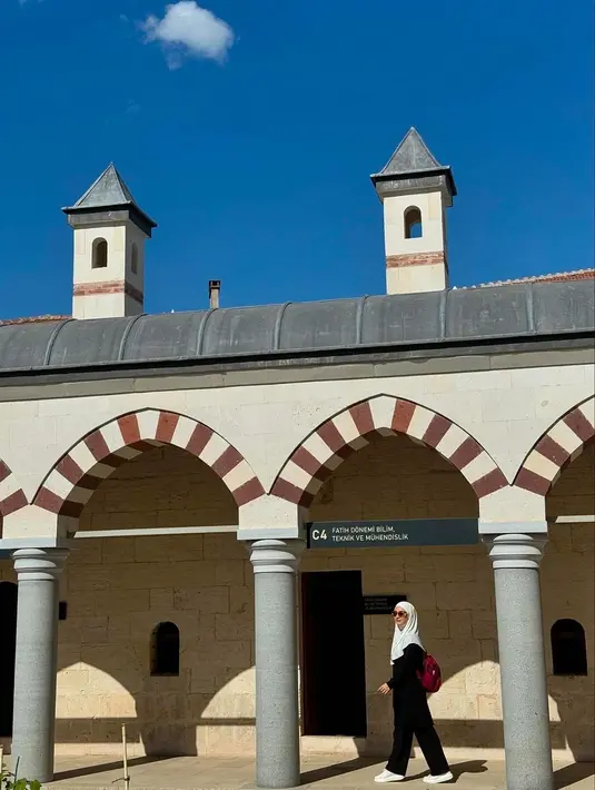 Gaya simple dengan atasan dan bawahan hitam, hijab putih, dan tas merah. [@_irishbella_]