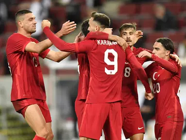 Penyerang Turki, Kenan Karaman (tengah) berselebrasi dengan rekan-rekannya usai mencetak gol ke gawang Jerman pada pertandingan persahabatan di Stadion RheinEnergie, Cologne, Kamis  (8/10/2020). Jerman bermain imbang 3-3 atas Turki. (AP Photo/Martin Meissner)