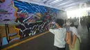 Warga mengambil gambar mural kolaborasi di Terowongan Kendal, Kawasan TOD Dukuh Atas, Jakarta, Rabu (6/7/2022). Disney Indonesia berkolaborasi bersama Jakarta Experience Board (JXB) dan Kita Art Friends menghadirkan karya seni mural terinspirasi dari film Marvel Studios "Thor: Love and Thunder." (Liputan6.com/Faizal Fanani)