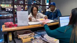 Sepasang calon pengantin Teaira Thompson dan James Anderson menyelesaikan dokumen mereka di Clark County Clerk's di Bandara Internasional McCarran di Las Vegas (12/2). Las Vegas ini menawarkan variasi pernikahan paling banyak. (AFP/L.E. Baskow)