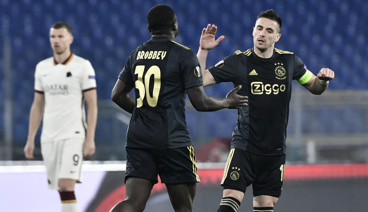 Striker Ajax Amsterdam, Brian Brobbey (kiri) berama Dusan Tadic merayakan gol yang dicetaknya ke gawang AS Roma dalam laga leg kedua perempatfinal Liga Europa 2020/2021 di Olimpico Stadium, Roma, Kamis (15/4/2021). Ajax bermain imbang 1-1 dengan AS Roma. (AFP/Filippo Monteforte)
