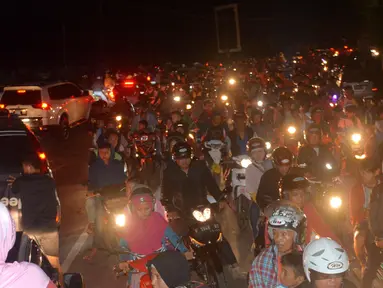 Sejumlah warga mengendarai motor mengungsi ke tempat yang lebih tinggi menyusul terjadinya gempa di Cilacap, Jawa Tengah (16/12). Gempa kuat yang mengguncang Pulau Jawa memicu peringatan akan terjadinya tsunami. (AP Photo / Wagino)