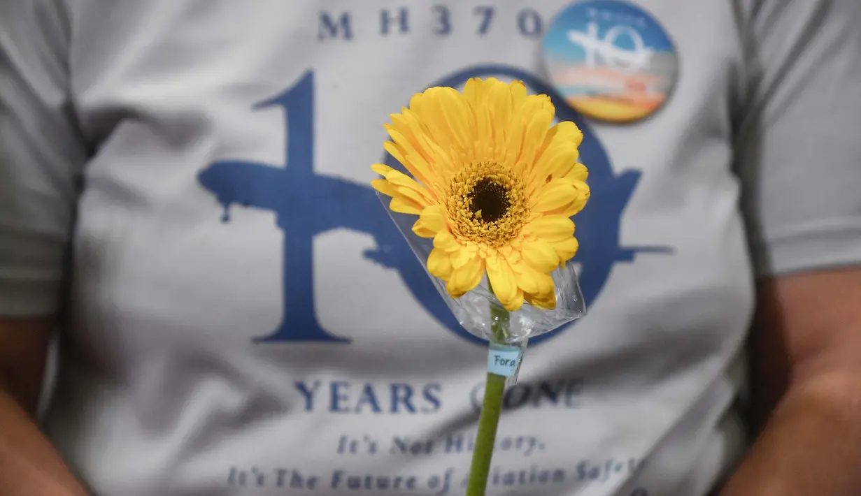 Seorang kerabat memegang bunga dalam sebuah acara yang diadakan oleh para kerabat penumpang untuk memperingati 10 tahun hilang pesawat Malaysia Airlines MH370, di Subang Jaya, pada tanggal 3 Maret 2024. (Arif Kartono/AFP)