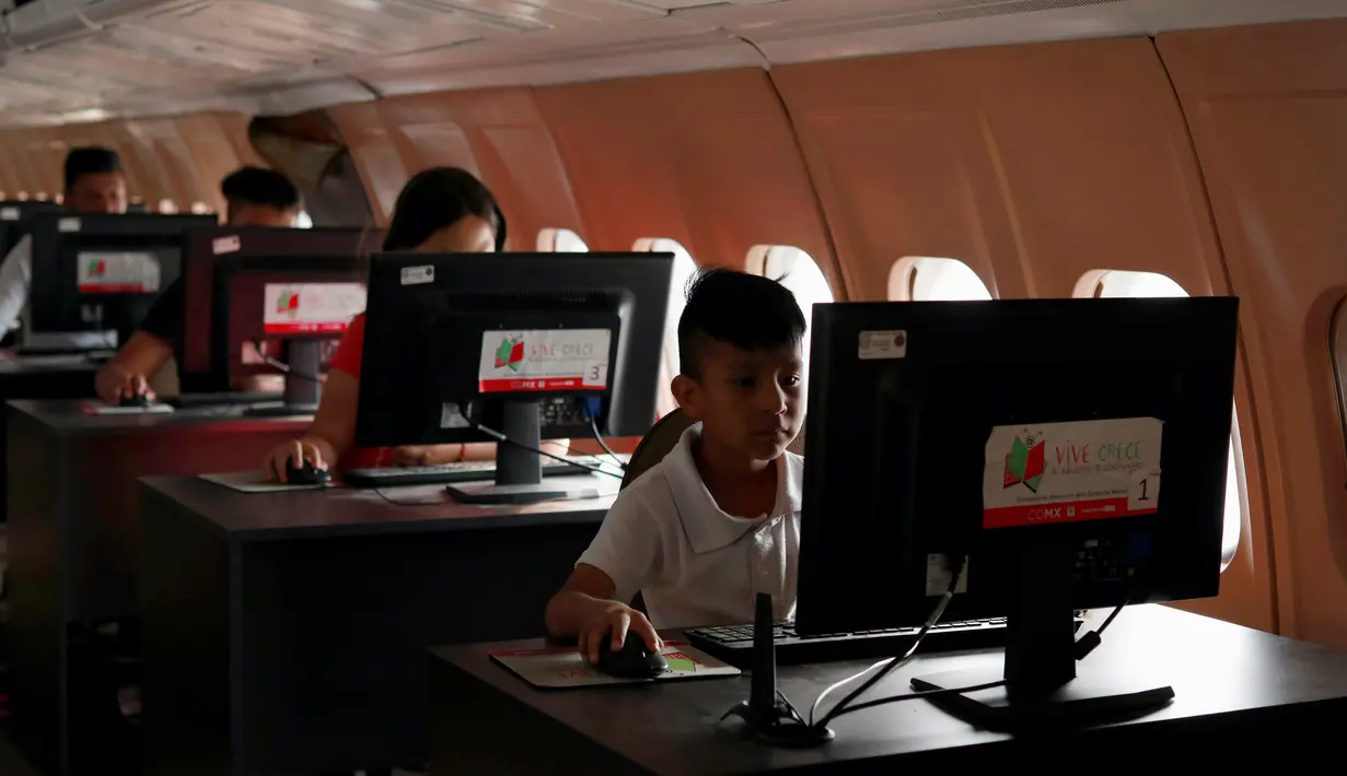 Sejumlah pengunjung menggunakan komputer di dalam pesawat McDonnell Douglas DC 9-14 yang diubah menjadi perpustakaan virtual di Mexico City, Meksiko (14/3). (Reuters/Henry Romero)