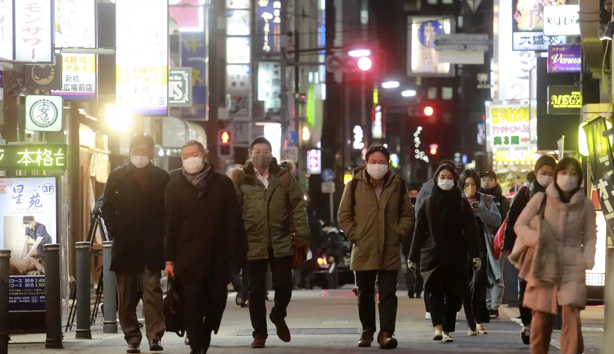 Orang-orang memakai masker untuk melindungi dari penyebaran virus corona berjalan di sepanjang jalan yang dipenuhi bar dan restoran di Tokyo, Rabu (19/1/2022). Tokyo dan puluhan daerah lain di Jepang akan menghadapi pembatasan COVID-19 baru yang berlaku efektif Jumat (21/1). (AP Photo/Koji Sasahara)
