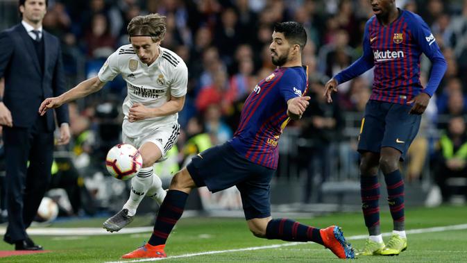 Gelandang Real Madrid, Luka Modric berusaha melewati striker Barcelona, Luis Suarez selama pertandingan lanjutan La Liga Spanyol di Santiago Bernabeu, Madrid (2/3). Barcelona menang tipis atas Real Madrid 1-0. (AP Photo/Andrea Comas)