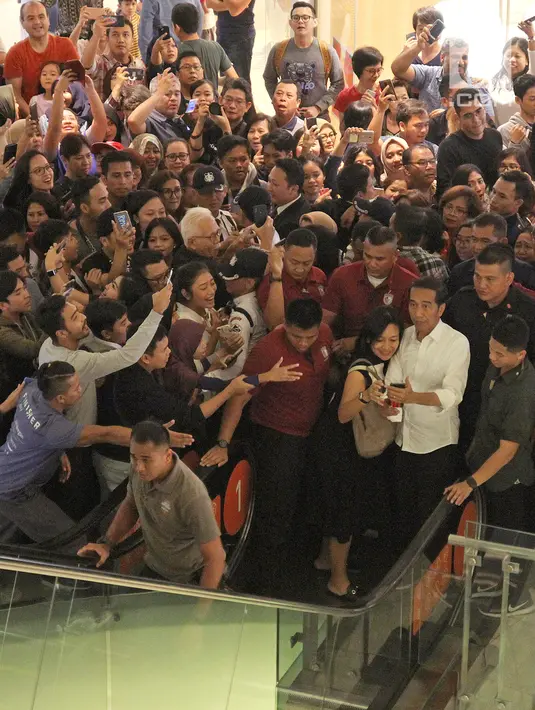 Pengunjung berebut mengambil foto Calon Presiden nomor urut 01, Joko Widodo atau Jokowi saat mengunjungi Grand Indonesia, Jakarta, Sabtu (20/4). Kedatangan Jokowi berkemeja putih bersama Ketua TKN Erick Thohir dan Wishnutama untuk makan siang bersama. (Liputan6.com/Herman Zakharia)