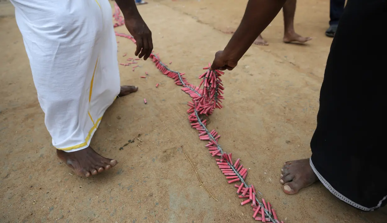 Warga bersiap menyalakan petasan usai mempersembahkan doa khusus sebelum pelantikan Wakil Presiden AS terpilih Kamala Harris di sebuah kuil Hindu di Thulasendrapuram, selatan Chennai, Tamil Nadu, India, Rabu (20/1/2021). Jelang Pemilu AS, warga juga mendoakan kesuksesan Harris. (AP Photo/Aijaz Rahi)