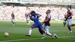 Pemain Chelsea, Raheem Sterling, terjatuh saat berusaha melewati pemain Burnley, Vitinho, pada laga pekan ke-8 Premier League 2023/2024 di Stadion Turf Moor, Sabtu, (7/10/2023). Pemain asal Inggris itu tampil luar biasa. Dia terlibat dalam semua gol The Blues di pertandingan tersebut. (Richard Sellers/PA via AP)