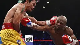 Aksi Floyd Mayweather Jr. saat mengalahkan Manny Pacquiao di MGM Grand Garden Arena, AS, Sabtu (2/5/2015). Menurut data media Forbes setiap tahun Mayweather membukukan penghasilan sebesar 300 miliar dollar AS. (AFP Photo/John Gurzinksi)