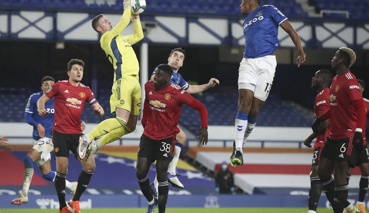 Kiper Manchester United, Dean Henderson melompat menangkap bola dari sundulan gelandang Everton, Yerry Mina pada babak perempat final di Goodison Park, Kamis (24/12/2020). Dengan kemenangan ini, MU berhasil melaju ke semifinal Piala Lifa Inggris 2020-2021. (AP Photo/Nick Potts,Pool)