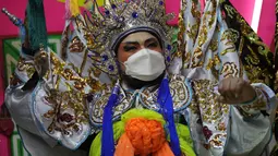 Seorang pemain opera memakai masker saat tampil di atas panggung di Bangkok, Rabu (6/10/2021). Sempat vakum, pertunjukan opera Tiongkok di Thailand kembali dihidupkan meski belakangan ini kasus harian Covid-19 kembali meningkat. (AP Photo/Sakchai Lalit)