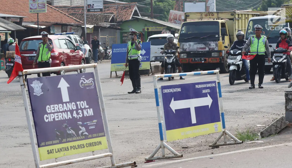 Aparat kepolisian Polres Cirebon Pantura mengatur lalu lintas kendaraan ke arah Tol Cipali, Indramayu, Jakarta dan ke arah Jawa Tengah di Pos Palimanan Cirebon, Jawa Barat, Jumat (30/6). (Liputan6.com/Helmi Afandi) 