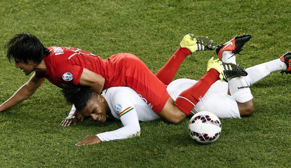 Pemain Bolivia, Leonel Morales (bawah) dijatuhkan oleh pemain Peru, Edwin Retamoso.  (AP Photo/Silvia Izquierdo)