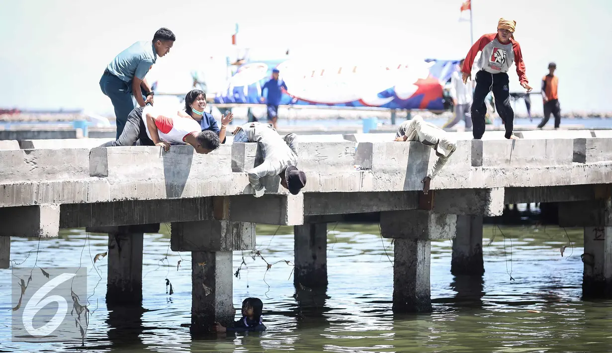 Warga dan petugas TNI AL menolong anak kecil yang terjatuh ke laut di dermaga Muara Angke, Jakarta, Kamis (24/3). Akibat kelalaian ibunya seorang anak tercebur ke laut dan langsung di selamatkan warga dan prajurit TNI AL. (Liputan6.com/Faizal Fanani)