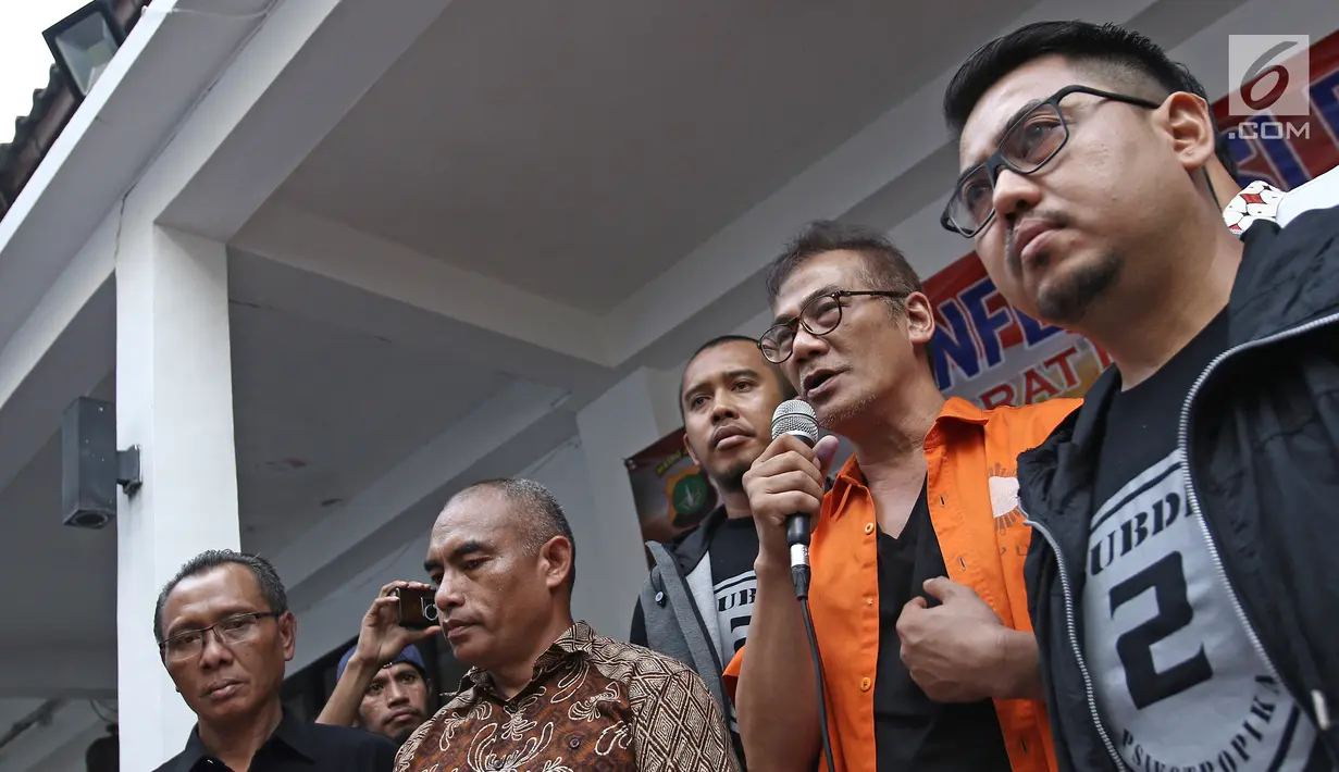 Tersangka Tio Pakusadewo saat jumpa pers di Dit Narkoba Polda Metro Jaya, Jakarta, Jumat (22/12). Aktor Tio Pakusadewo di tangkap polisi terkait kepemilikan tiga bungkus plastik klip sabu 1,06 gram. (Liputan6.com/Herman Zakharia)