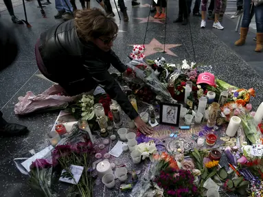 Penggemar meletakkan bunga di atas nama penyanyi legendaris David Bowie di Hollywood Walk of Fame di Los Angeles, Senin (11/1). Bowie meninggal di usianya yang ke 69 tahun dan baru saja merilis album ke-25 nya yaitu "Blackstar". (REUTERS/Mario Anzuoni)