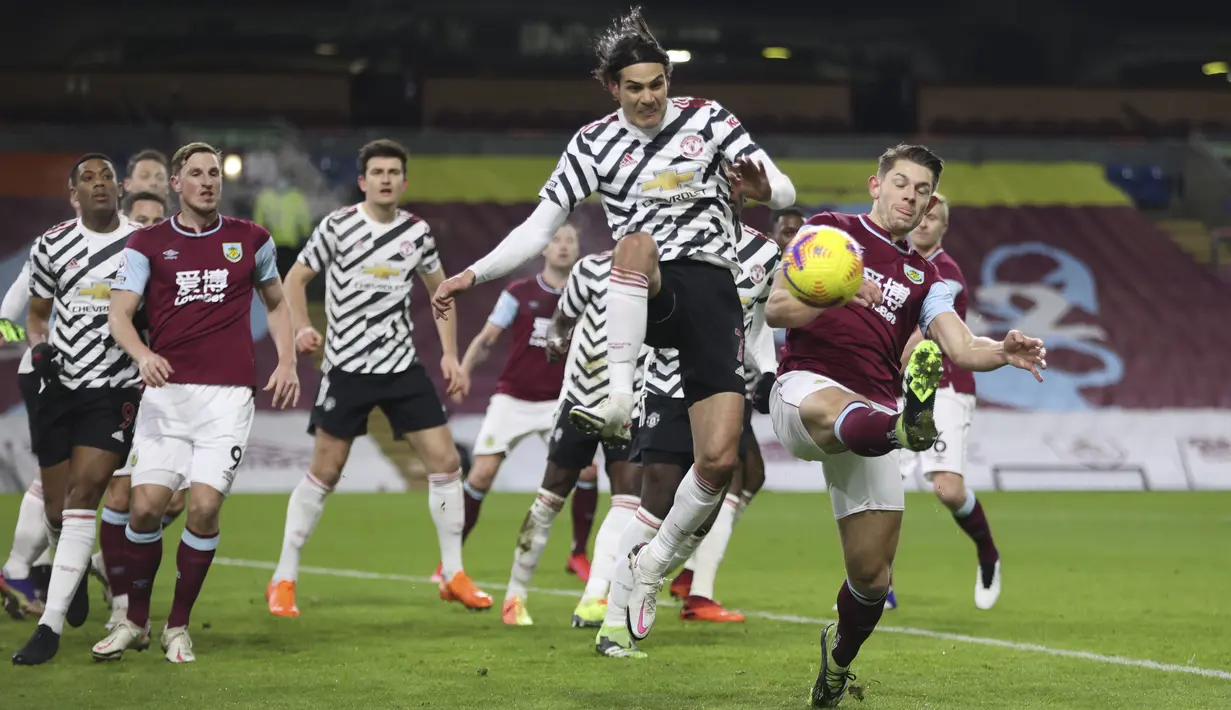 Penyerang Manchester United, Edinson Cavani berebut bola saat menghadapi Burnley dalam partai tunda Liga Inggris 2020/21 di Turf Moor, Rabu (13/1/2021) dini hari WIB. Manchester United sukses mengalahkan Burnley dengan skor tipis 1-0. (Clive Brunskill/Pool via AP)