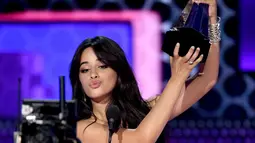 Penyanyi Camila Cabello mengangkat piala pertamanya pada ajang American Music Awards 2018 di Microsoft Theater, Los Angeles, Selasa (9/10). Lewat lagu 'Havana', Camilla dianugerahi sebagai Lagu Pop/Rock Terfavorit 2018. (Kevin Winter/Getty Images/AFP)