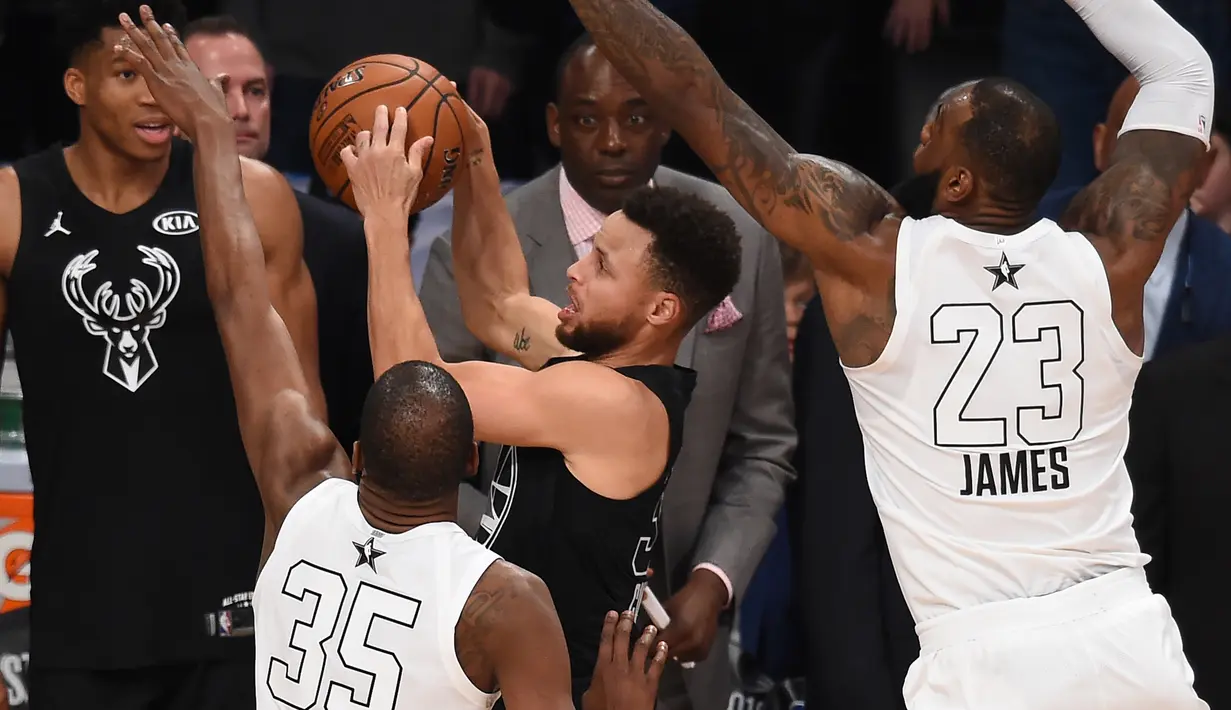 Kevin Durant (kiri)  dan LeBron James (kanan) menutup pergerakan Stephen Curry (tengah) pada laga NBA All-Star basketball game di Los Angeles, (18/2/2018). Tim LeBron menang 148-145. (AFP/ Robyn Beck)