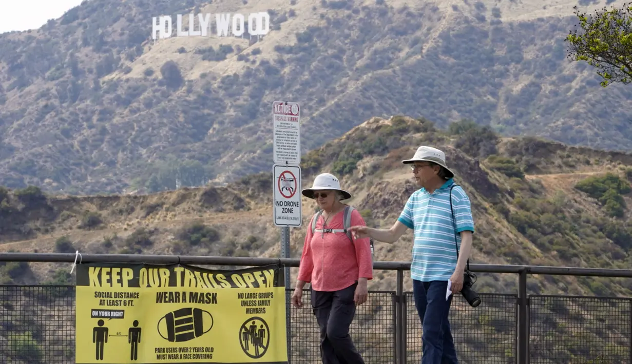 Pengunjung terlihat tanpa masker di Observatorium Griffith di Los Angeles, Senin (17/5/2021). California mempertahankan aturan untuk mengenakan masker hingga negara bagian itu mencabut pembatasan COVID-19 pada 15 Juni mendatang. (AP Photo/Damian Dovarganes)
