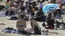 Orang-orang menikmati cuaca hangat di Ruislip Lido di London, Selasa (30/3/2021).  Suhu di beberapa bagian Inggris diperkirakan akan lebih hangat secara signifikan minggu ini karena keluarga dan teman berkumpul kembali dan kegiatan olahraga luar ruangan diizinkan untuk dilanjutkan di Inggris. (AP Ph