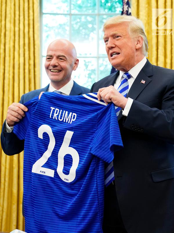 Presiden AS Donald Trump berpose dnegan jersey yang diberikan presiden FIFA, Gianni Infantino selama pertemuan di Oval Office Gedung Putih, Selasa (28/8). Presiden FIFA bertemu Trump untuk membahas kesiapan Piala Dunia 2026. (AFP/Mandel Ngan)