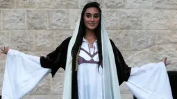 Senyum seorang model saat mengikuti peragaan busana tradisional Palestina di Kota Tua Nablus, Tepi Barat, Palestina, Selasa (22/8). Peragaan busana ini sebagai salah satu upaya untuk melestarikan budaya Palestina. (AFP Photo/Jaafar Ashtiyeh)