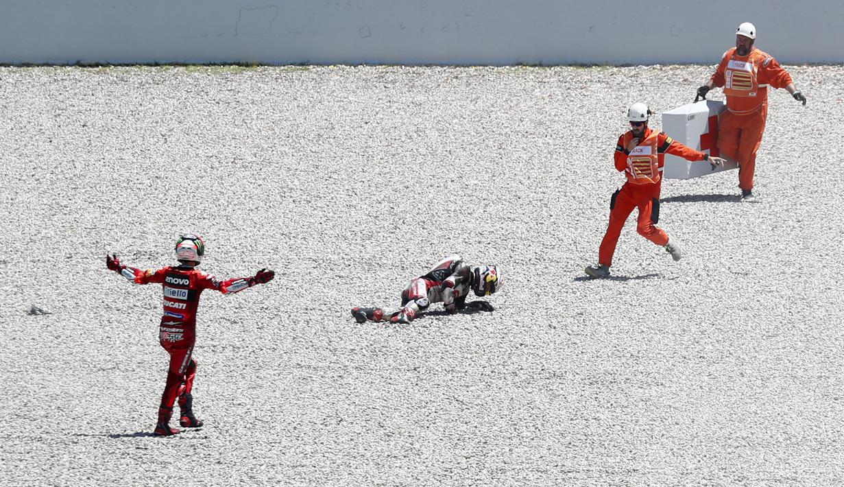 Francesco Bagnaia (kiri) yang awalnya berusaha menahan agar tidak jatuh, akhirnya juga ikut dalam insiden tersebut. (AP/Joan Monfort)
