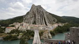 Pebalap Tour de France melewati kota Sisteron dengan bukit yang unik pada etape ke-29 dengan jarak tempuh 222,5 km dari Embrun menuju Salon-de-Provence, Prancis, (21/7/2017). (AP/Christophe Ena)