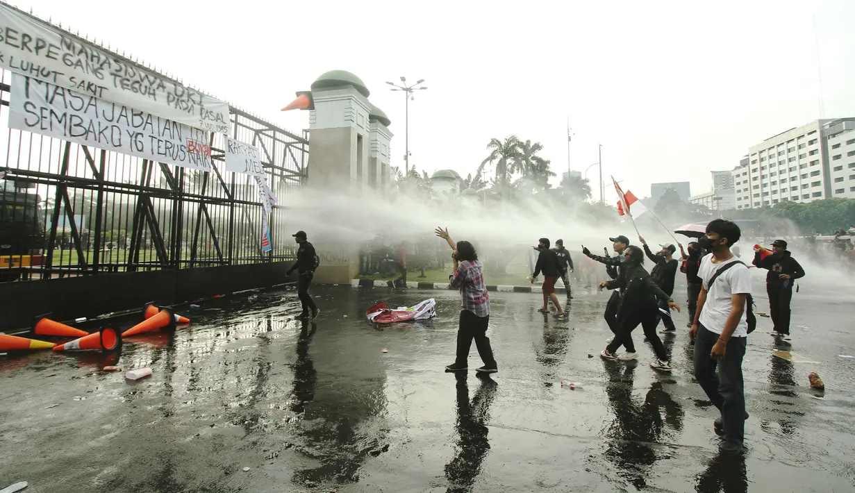 Aparat kepolisian melepaskan water canon untuk membubarkan massa aksi demo mahasiswa di depan Gedung DPR, Jakarta, Senin (11/4/2022). Mahasiswa yang tergabung dalam aliansi BEM SI menggelar unjuk rasa besar-besaran di depan Gedung DPR/MPR RI, Senin ini. (Liputan6.com/Angga Yuniar)