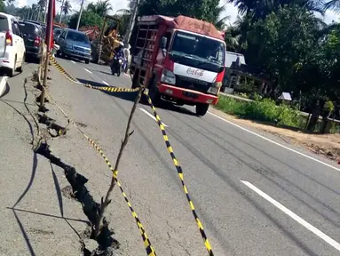 Kendaraan melintasi jalan retak di Kabupaten Pidie Jaya, Aceh, Kamis (8/12). Gempa berkekuatan 6,5 SR pada Rabu pagi menyebabkan sejumlah ruas jalan retak dan mengalami kerusakan. (Liputan6.com/Angga Yuniar)