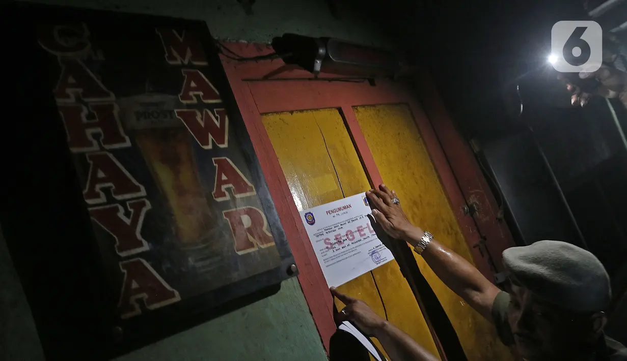 Petugas menyegel salah satu warung remang-remang di gang royal kawasan Penjaringan, Jakarta, Senin (10/2/2020). Pemkot Jakarta Utara bersama instansi terkait, melakukan penyegelan bangunan dan Penertiban Pemakaian Tenaga Listrik (P2TL) di kawasan Gang Royal. (Liputan6.com/Herman Zakharia)