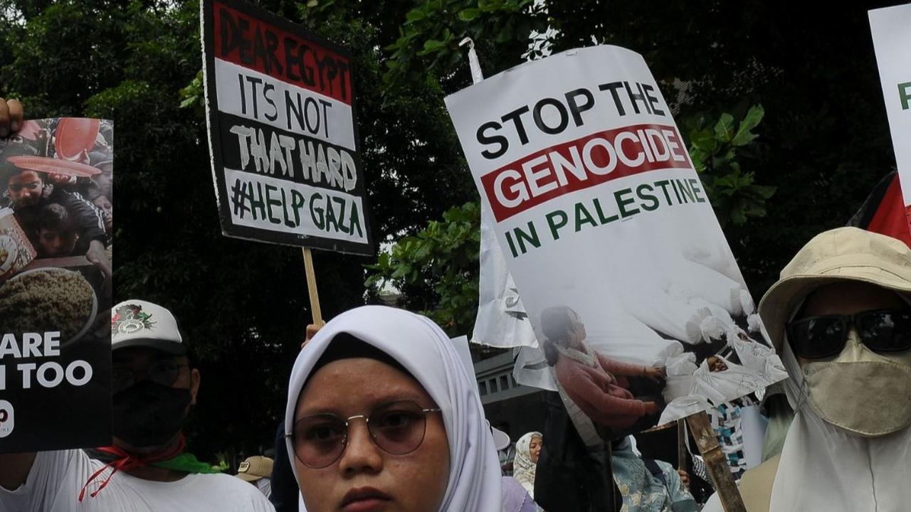 Selain piring, berbagai poster bertuliskan "Stop genosida"mereka tunjukkan selama beraksi. Foto merdeka.com / Imam Buhori<br>