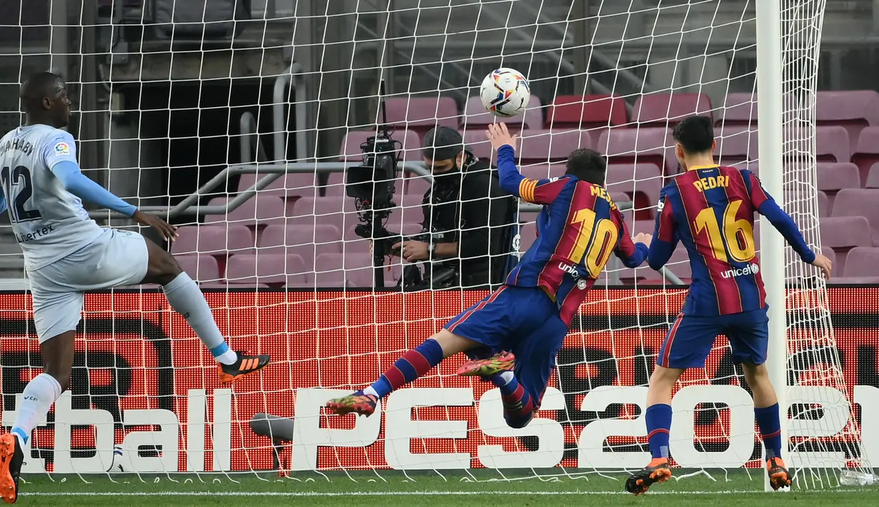 Striker Barcelona, Lionel Messi (kedua dari kanan), mencetak gol pertama timnya lewat sundulan kepala ke gawang Valencia dalam laga lanjutan Liga Spanyol 2020/21 di Camp Nou Stadium, Barcelona, Sabtu (19/12/2020). Barcelona bermain imbang 2-2 dengan Valencia. (AFP/Lluis Gene)