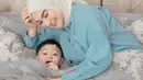 Irish Bella berpose bersama anak sulungnya. Mengenakan kemeja berwarna biru muda dengan hijab berwarna putih gading yang simpel memancarkan kecantikan seorang ibu yang sangat menyayangi sang anak. Foto: Instagram.