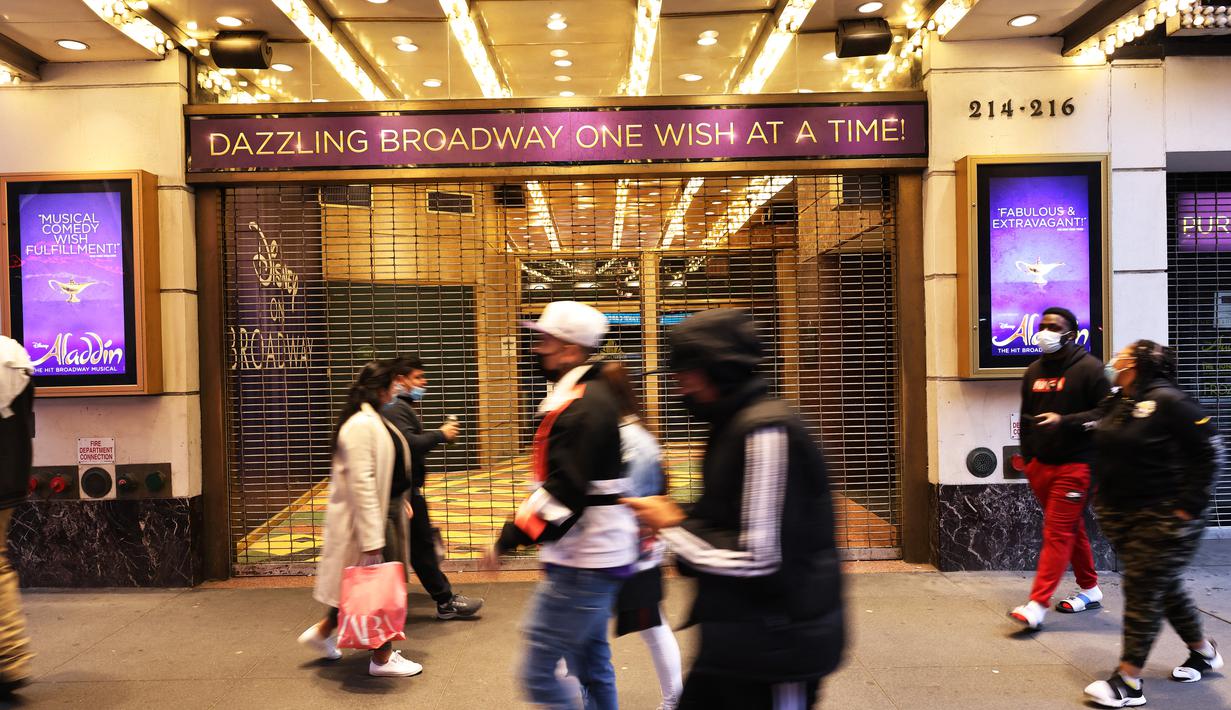 Orang-orang berjalan melewati Theater District di Manhattan, New York City, Kamis (6/5/2021). Gubernur Andrew Cuomo mengumumkan teater Broadway akan dibuka kembali dalam kapasitas penuh mulai 14 September, sejak ditutup Maret 2020 karena pandemi COVID-19. (MICHAEL M. SANTIAGO/GETTY IMAGES VIA AFP)Or