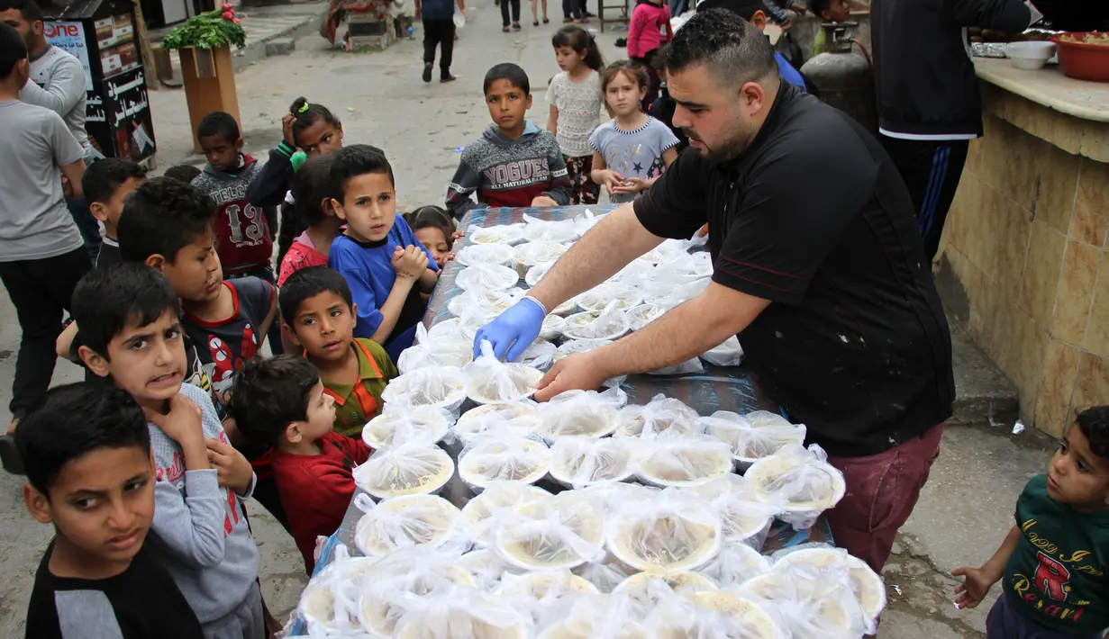 Seorang pekerja Palestina menyiapkan makanan gratis pada hari keempat Ramadan di Deir al-Balah, Jalur Gaza tengah, pada 27 April 2020. Warga Palestina merayakan Ramadan, bulan suci umat Islam, di tengah situasi ekonomi yang memburuk akibat pandemi COVID-19. (Xinhua/Rizek Abdeljawad)