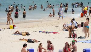 Orang-orang berkumpul di Pantai Bondi saat merayakan Natal di Sydney, Sabtu (25/12/2021). (AP Photo/Rick Rycroft)