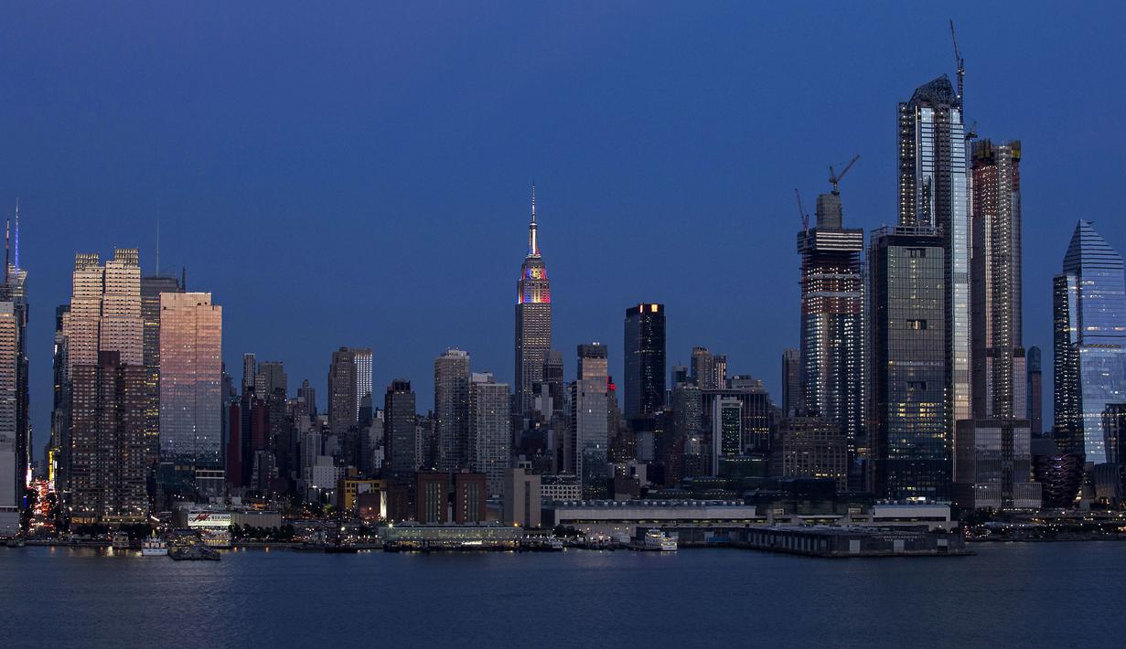 Lampu warna bendera juara Piala Dunia 2018, Prancis, mewarnai gedung pencakar langit Empire State di New York, Minggu (15/7). Meski gagal lolos Piala Dunia 2018, Amerika Serikat memiliki cara tersendiri memeriahkan ajang itu. (AFP PHOTO / KENA BETANCUR)