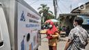 Warga memasukkan sampah saat menabung di ATM Sampah Keliling di Semper Barat, Cilincing, Jakarta Utara, Selasa (12/10/2021). Tiap warga atau nasabah nantinya diberikan rekening melalui aplikasi smartphone sebagai bukti menabung sampah yang dapat dicairkan menjadi uang. (merdeka.com/Iqbal S. Nugroho)