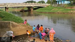 Sejumlah ibu bersama anaknya mencari ikan dan udang di bantaran Kanal Banjir Timur, Cipinang Muara, Jakarta, Selasa (16/5). Kegiatan itu dilakukan para ibu dan anak-anaknya untuk mengisi masa libur sekolah. (Liputan6.com/Immanuel Antonius)