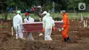Petugas menggotong peti jenazah pasien Covid-19 di TPU Tegal Alur, Jakarta, Rabu (15/4/2020). Juru bicara pemerintah untuk penanganan virus corona Achmad Yurianto menyampaikan per Rabu (15/4) jumlah pasien terkonfirmasi 5.136 dan meninggal 469 orang. (Liputan6.com/Helmi Fithriansyah)
