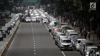 Suasana saat ratusan sopir taksi online memarkir mobilnya di Jalan Medan Merdeka Barat, Jakarta, Rabu (14/2). Para pengemudi menolak Permenhub Nomor 108 karena dianggap memberatkan. (Liputan6.com/Arya Manggala)