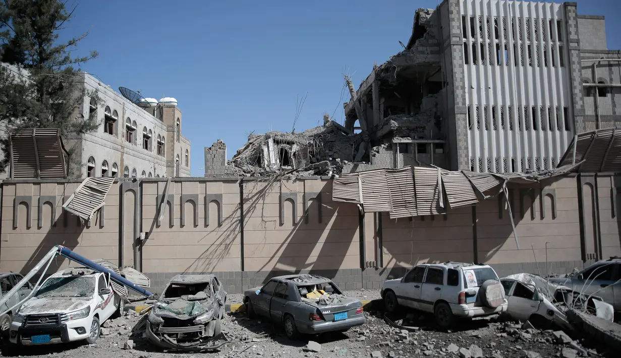 Kondisi bangungan dan mobil yang rusak parah usai terjadi serangan udara di kompleks kepresidenan, di Sanaa, Yaman (7/5). Sebelumnya kompleks kepresidenan ini telah dikuasai oleh kelompok pemberontak Houthi. (AP Photo/Hani Mohammed)
