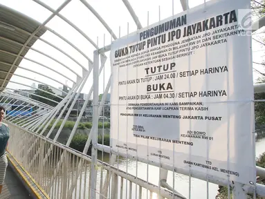 Spanduk besar pengumuman jam buka tutup terpampang di Jembatan Penyeberangan Orang (JPO) Jayakarta di Jakarta, Rabu (25/10). JPO ini menghubungkan Jalan Menteng Tenggulun dan Jalan Sultan Agung. (Liputan6.com/Immanuel Antonius)