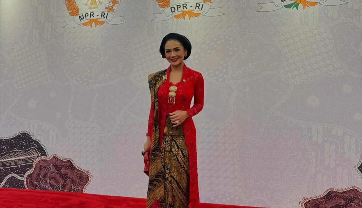 Tahun ini, Krisdayanti memilih mengenakan kebaya brokat merah panjang dipadukan selendang batik senada dengan bawahan kainnya. Krisdayanti pun melengkapi tampilannya dengan berbagai aksesori seperti anting-anting keemasan dengan permata merah, bros keemasan motif kupu-kupu, dan bros besar di bagian depan.