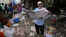 Seorang pria membaca koran di pasar grosir di Bengaluru, India, Rabu (13/4/2022). Orang-orang telah kembali beraktivitas normal setelah pihak berwenang mencabut pembatasan COVID-19 termasuk mengenakan masker wajah di tempat-tempat umum. (AP Photo/Aijaz Rahi)